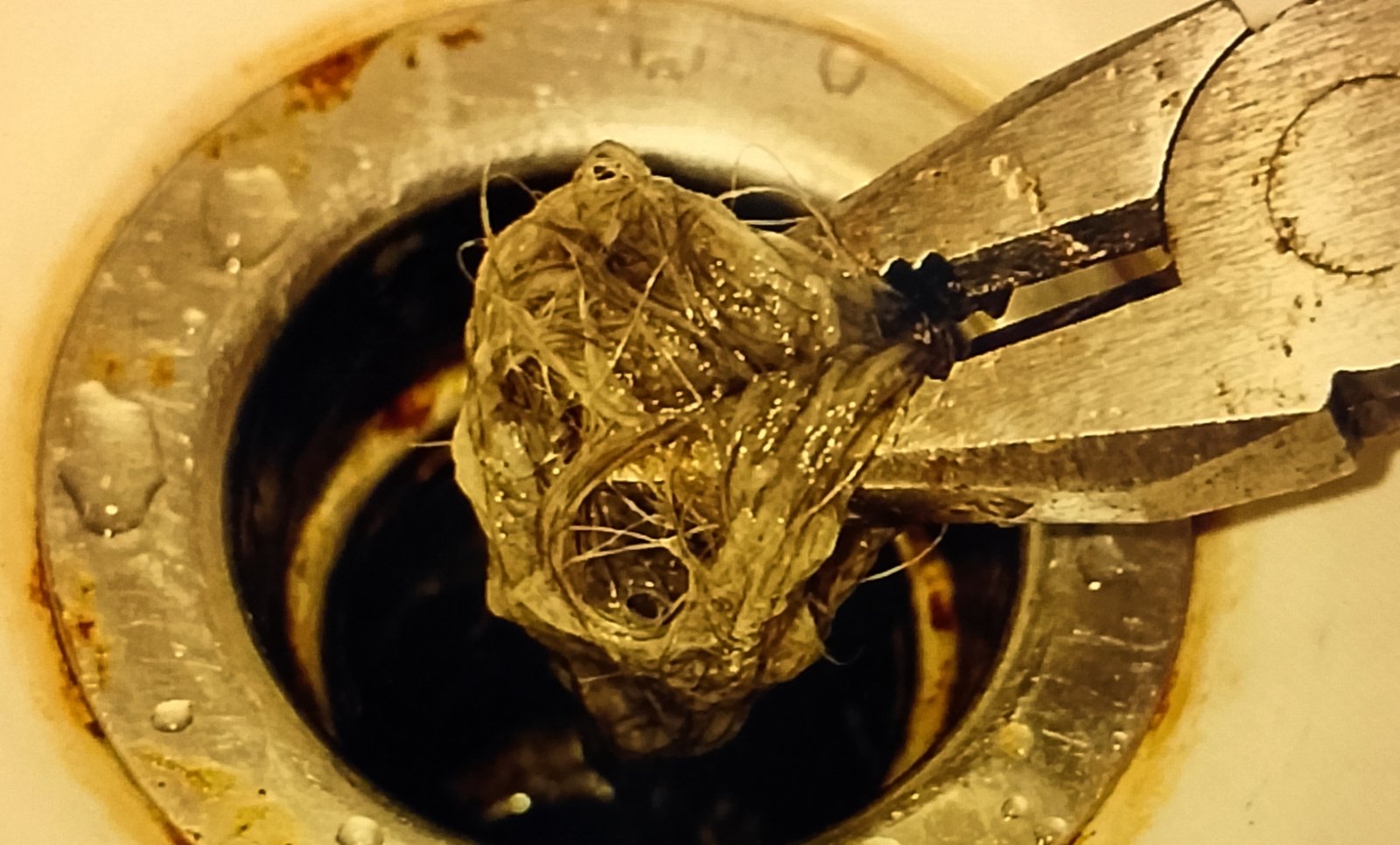 drain Pliers pulling hair clump out of sink drain