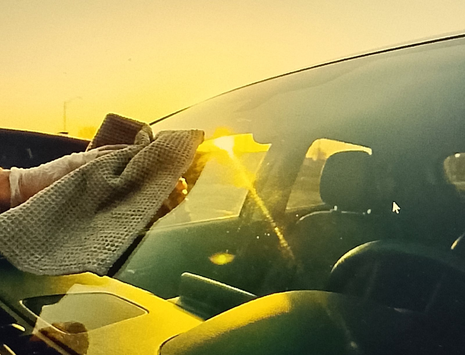 cleaning windshield Buffing the windshield dry with a microfiber towel
