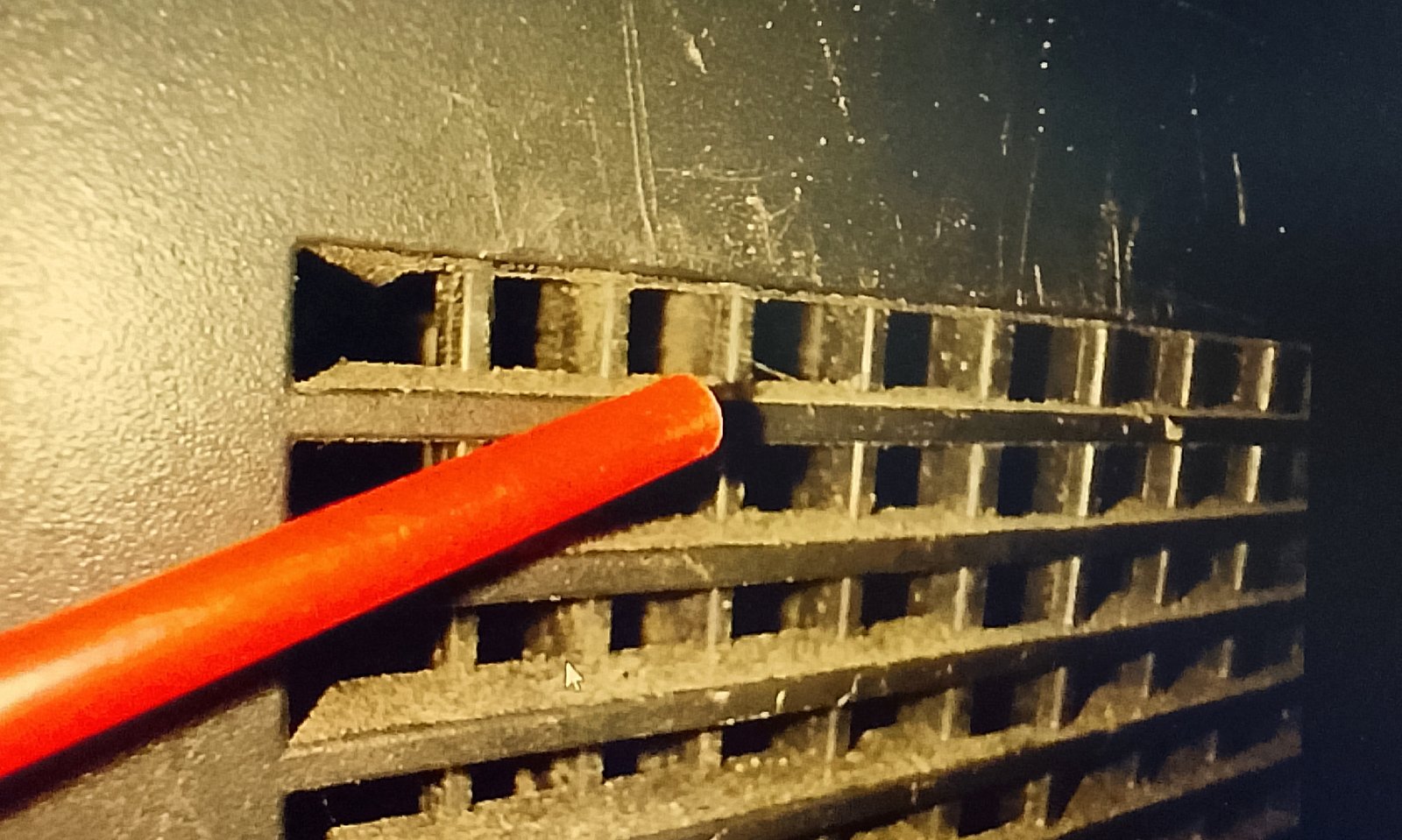Compressed air straw angled sideways against the Xbox vent grill