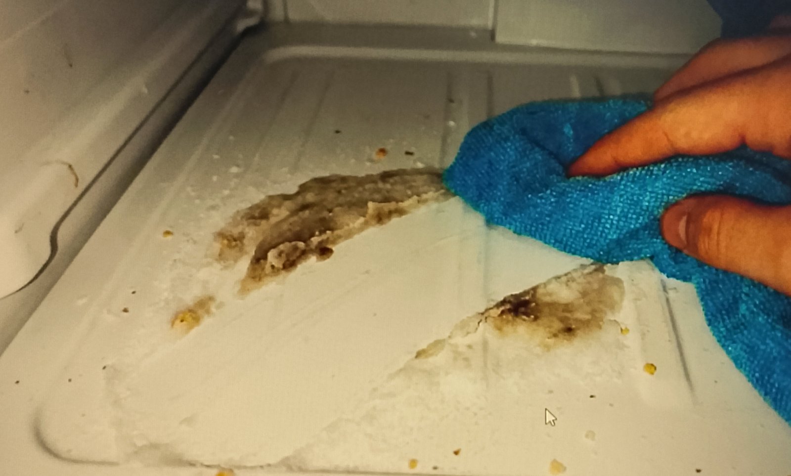 microfiber cloth Cleaning a freezer shelf with a microfiber cloth