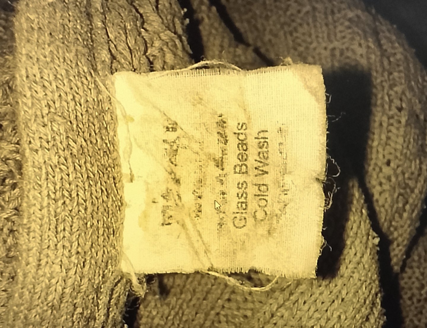 Care tag on a grey weighted blanket showing glass beads
