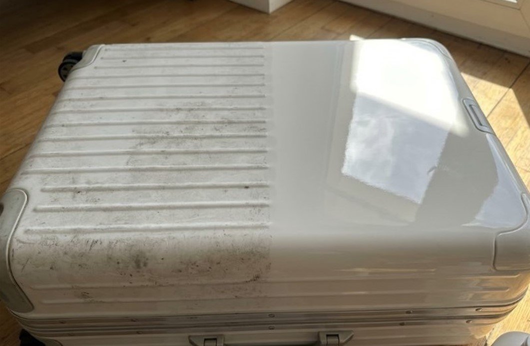Cleaning white Rimowa Essential Lite polycarbonate shell with soft microfiber cloth and dish soap foam