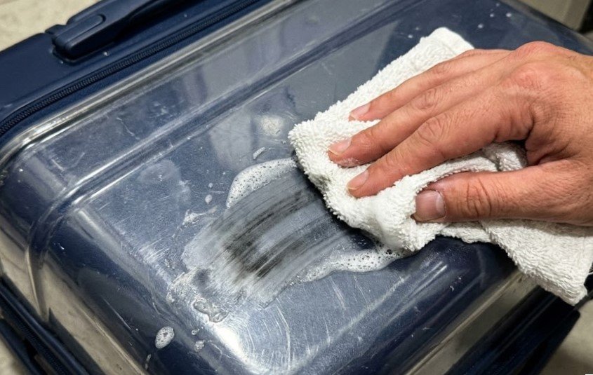 the hand scrubbing a black streak off the plastic