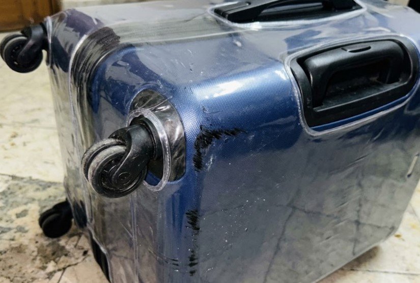 the plastic cover pulled tight over a hard suitcase