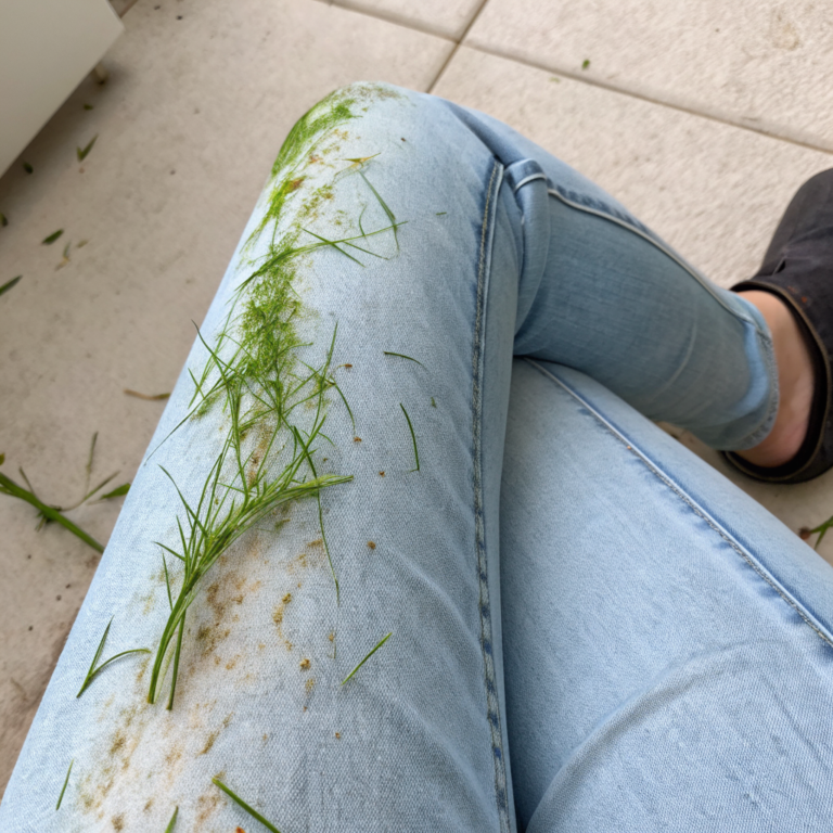 A2zSj7hsSTOnjDdpdiRKR KORJ6Gob Green grass streaks smeared across denim fabric near the knee area