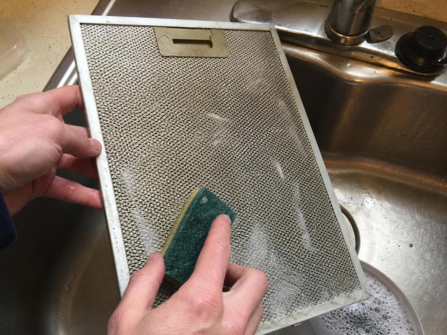 Close-up household cleaning method for how to clean a range hood filter; best way to clean a range hood filter; clean a range hood filter without damage; safe cleaner for a range hood filter; a range hood filter cleaning mistakes; how often to clean a range hood filter